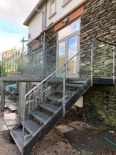 Beespoke balcony with forged railing and matching fixings and glass panelling.
